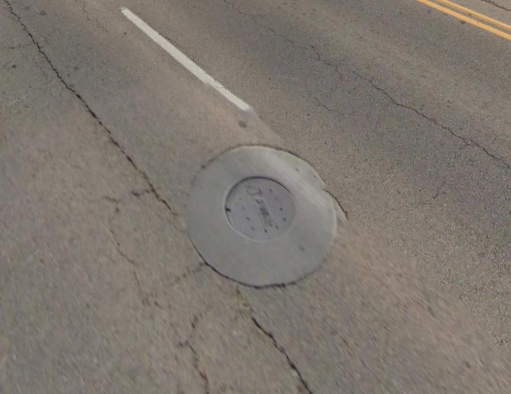 This is an example of a utility lid on 9000 South that has not been lowered. Crews will remove the concrete and place the lid into the ground prior to milling the road.